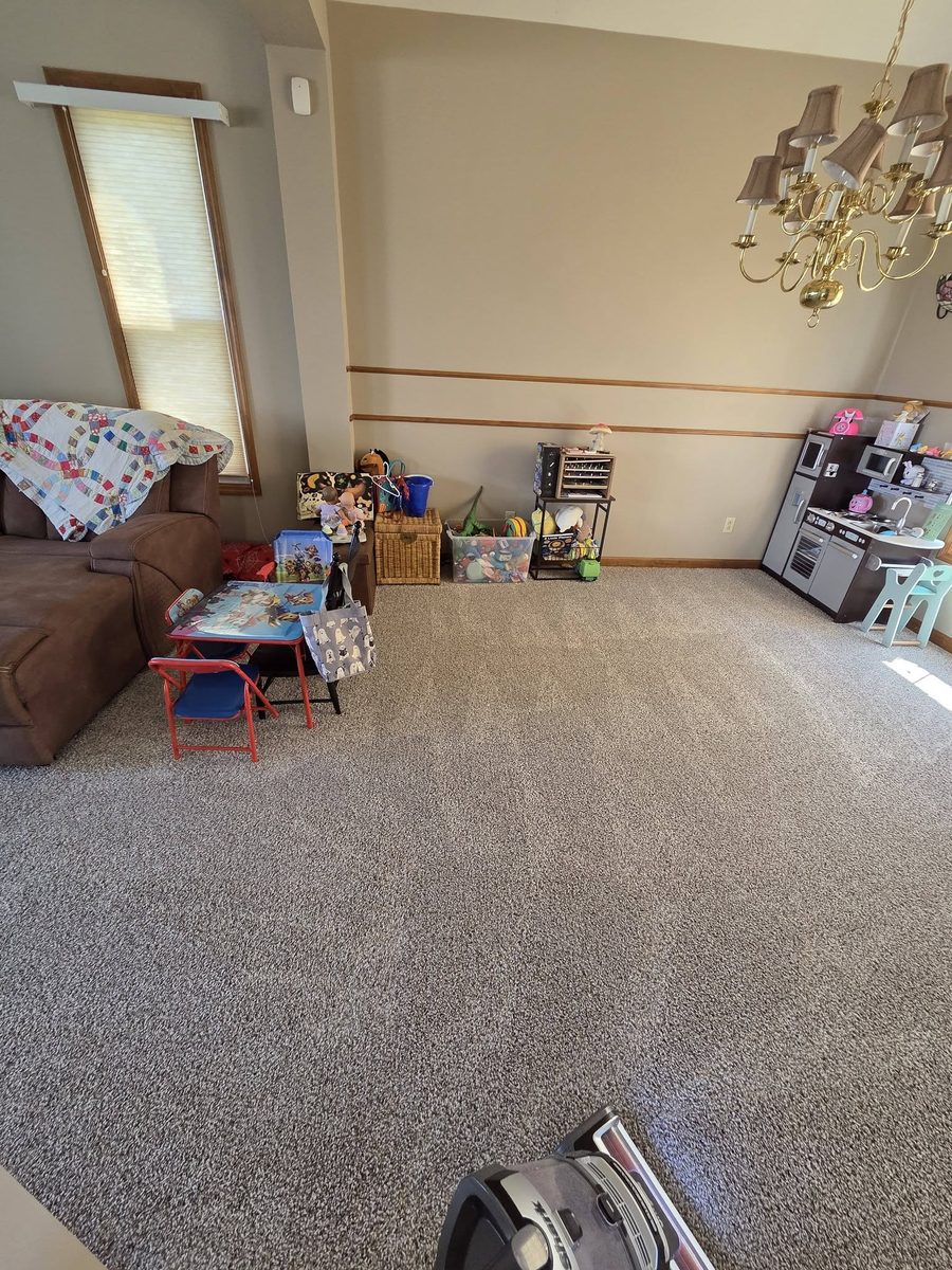 A playroom with the carpet vacuumed and the toys tidied to the walls