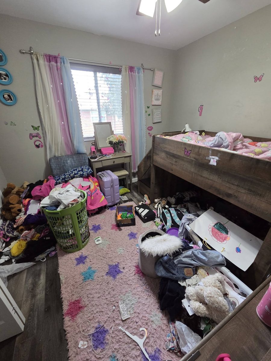 A child's bedroom with clothes and toys covering the floor before cleaning